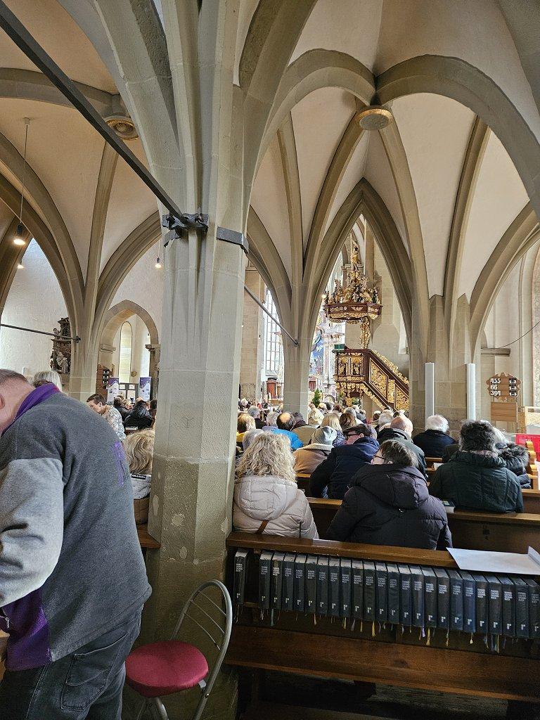 Blick von hinten in die Kirche. Die Plätze sind alle besetzt.