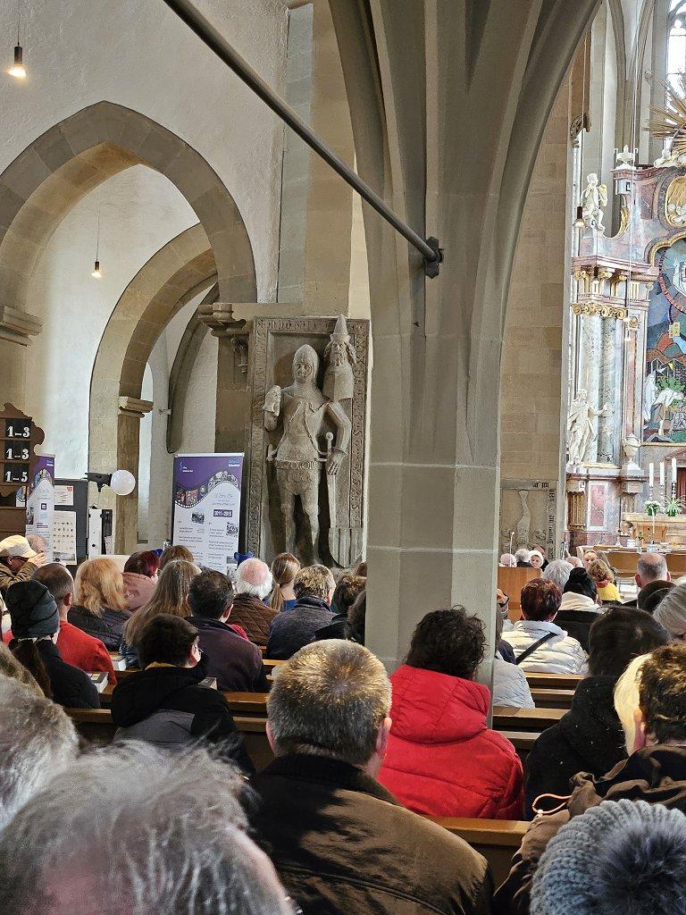 Blick von hinten in die Kirche. Die Plätze sind alle besetzt.