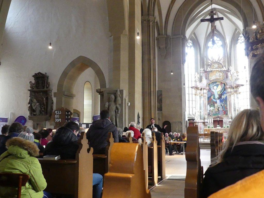 Pfarrer Carsten Bräumer im Talar am Lesepult, Blick von weiter hinten