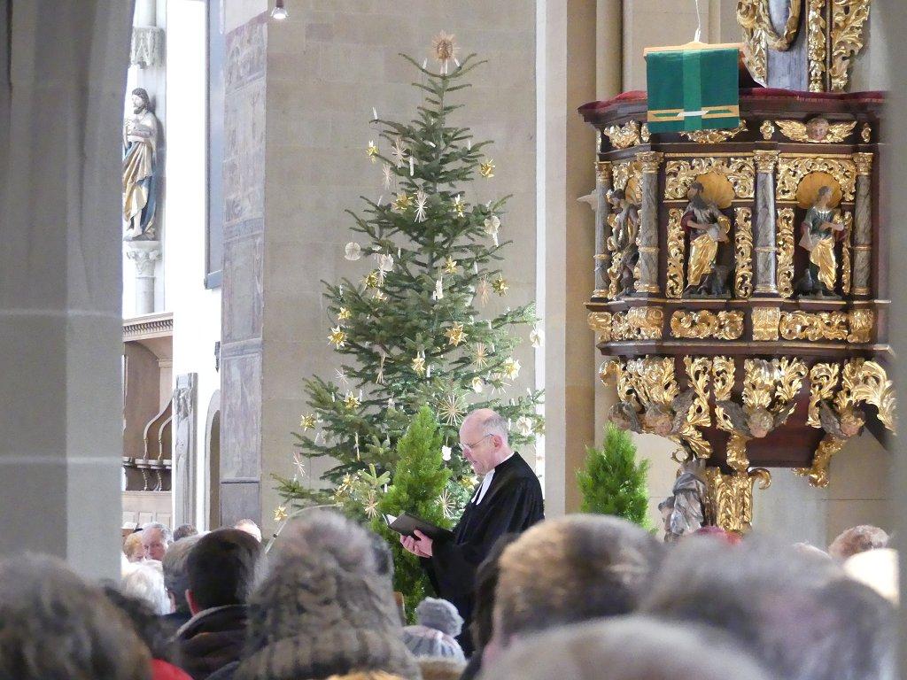 Dekan Oliver Bruckmann setzt das Abendmahl ein. Im Hintergrund der Weihnachtsbaum.